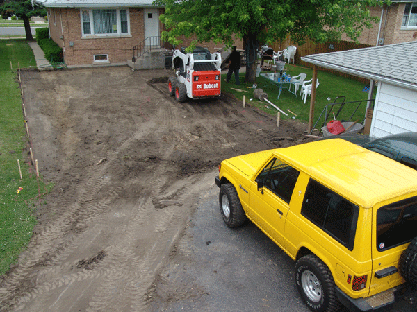 Before picture of Bobcat grading back yard in preparation for new concrete driveway.