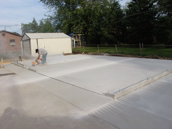 Finishing the cutting in of control joints in 4 car garage slab with side drive. 