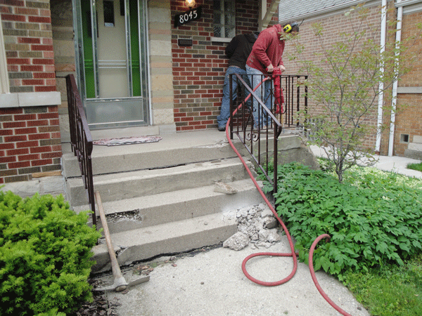 Picture of existing stairs being broken out with a Jack Hammer