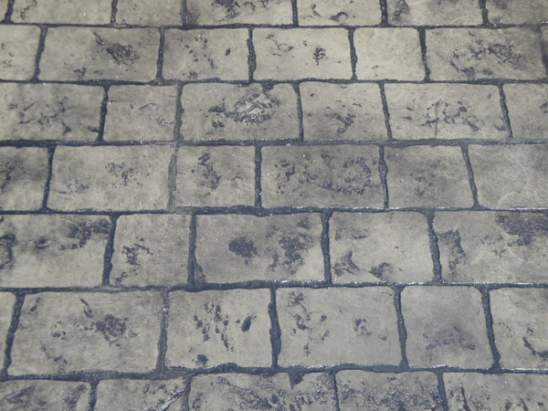 Close-up of Mayan Cobblestone stamped concrete with Millstone base and Storm Grey release color